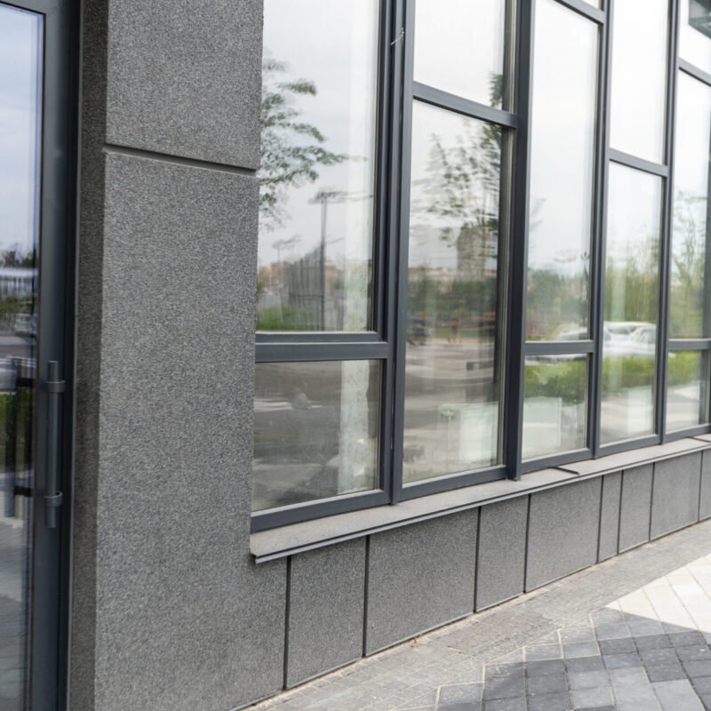 Abstract fragment of modern architecture, gray walls, glass and concrete.