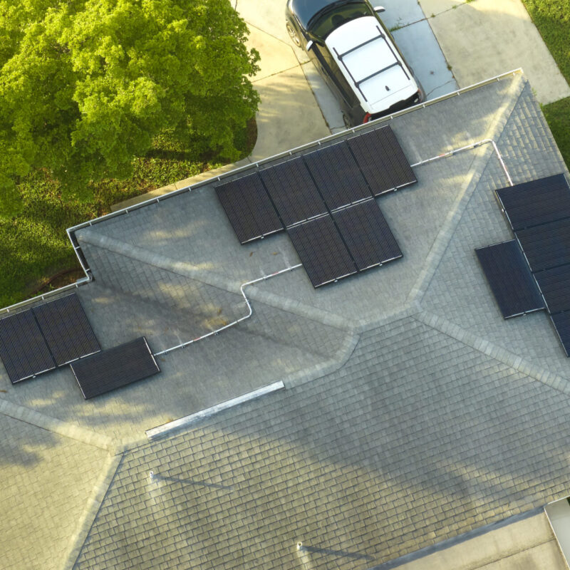 Aerial view building roof with rows of blue solar photovoltaic panels for producing clean ecological electric energy. Renewable electricity with zero emission concept